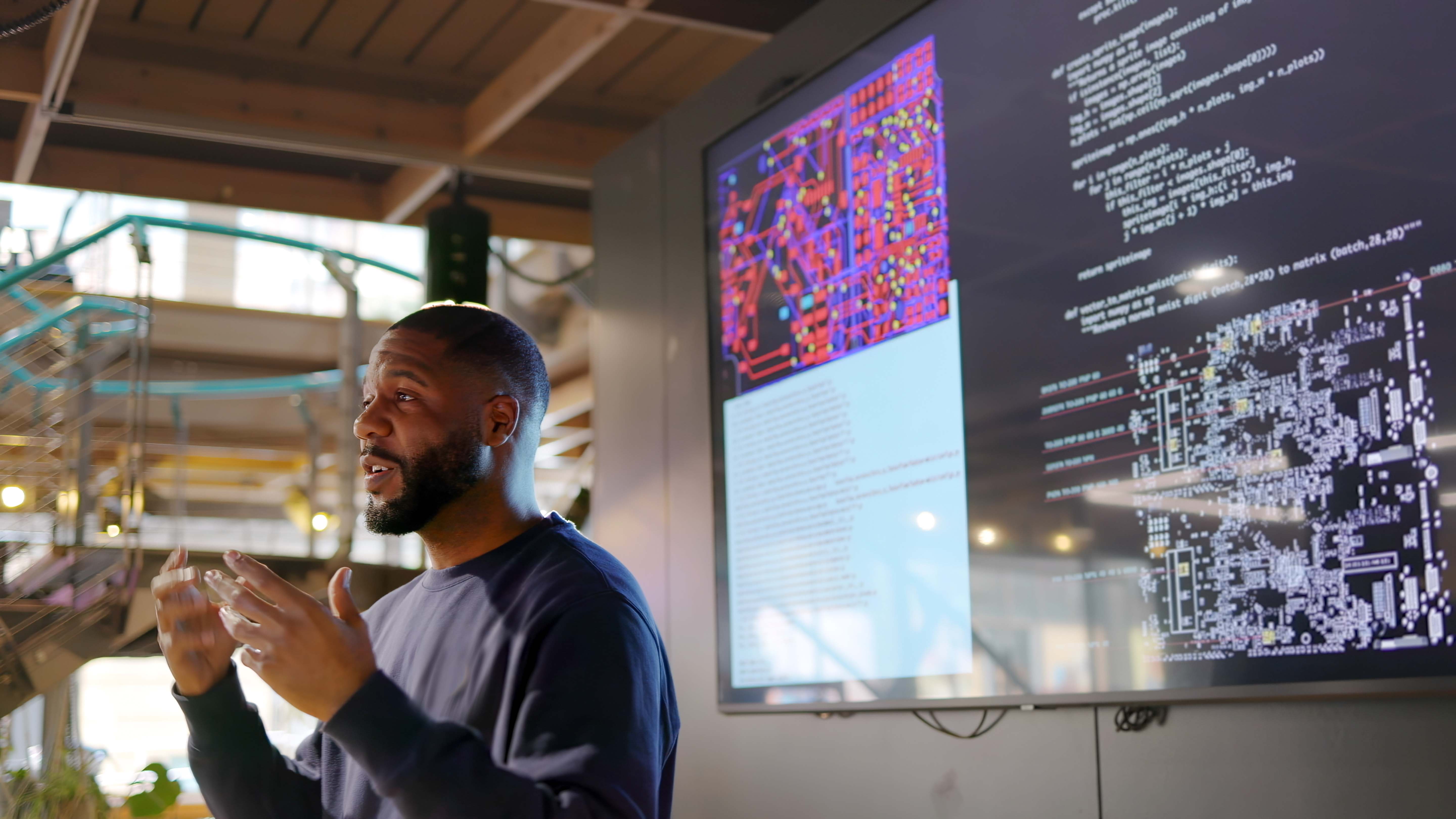 Man speaking in front of a screen