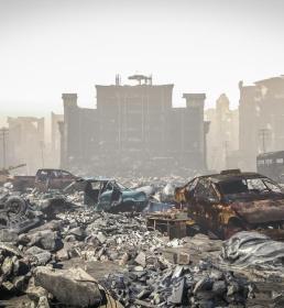 Rubble from a bombed building and burnt-out cars 