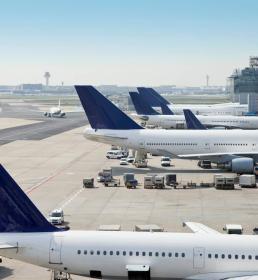 Planes lines up in an airport are loaded with cargo