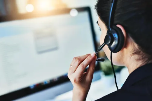 A woman takes a call on a headset